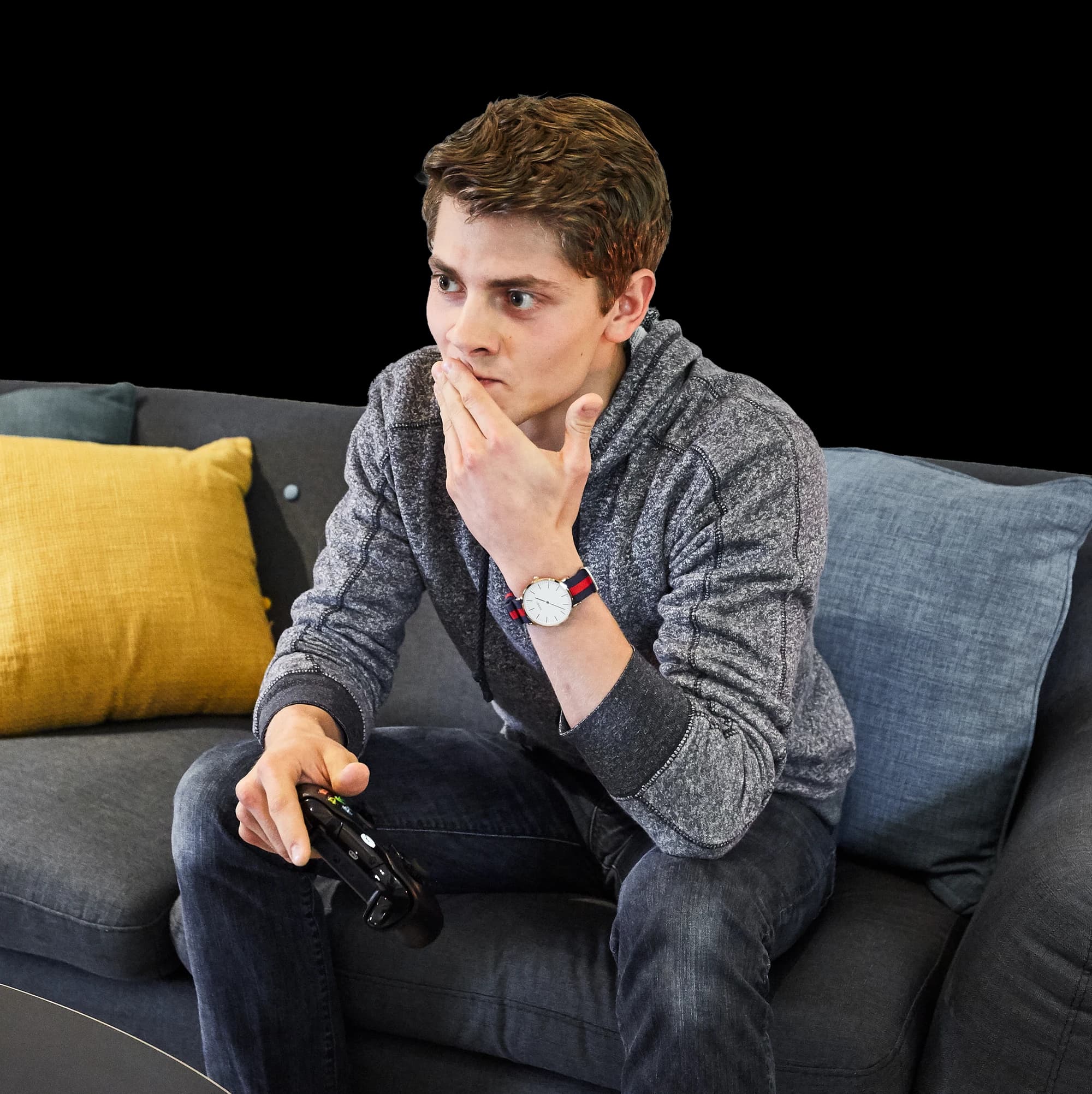 A player on a couch holding an Xbox controller, looking unsure what to do next.